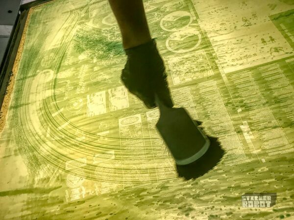 Screen printer cleaning mesh screen between silkscreen passes